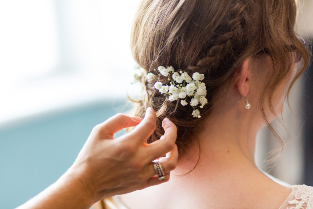 Finishing touches to a loose and low textured bridal hair style. Gypsophila adding romance to a relaxed wedding updo