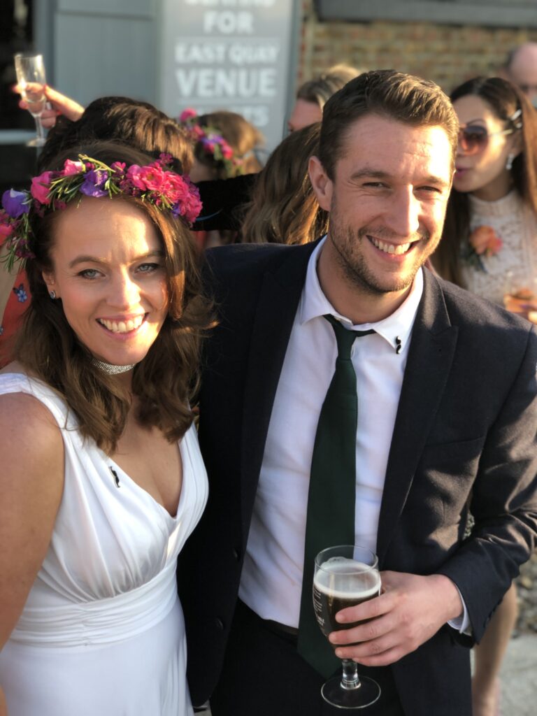 Happy couple. Bridesmaid in white with colourful flower crown