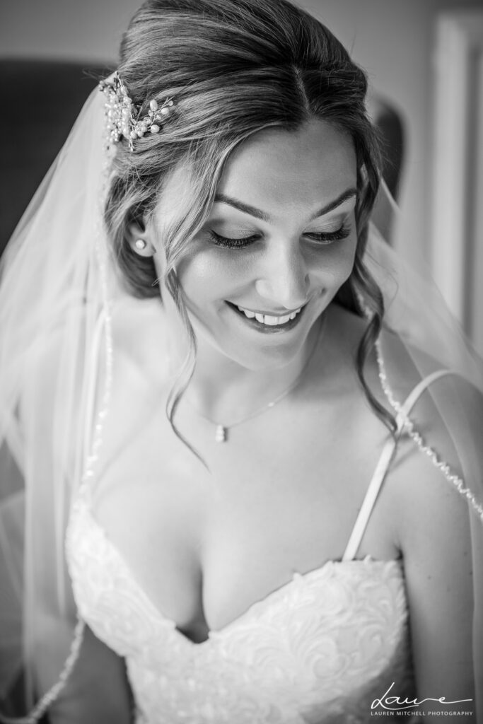 Beautiful modern bride looking down and showing off stunning hair and makeup